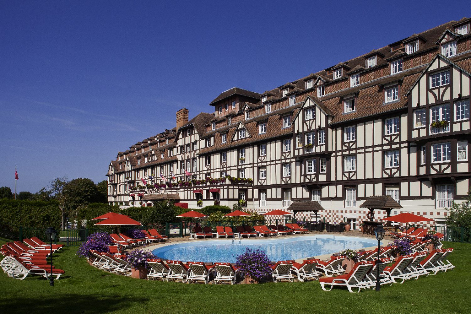 golf-expedition-golf-reizen-frankrijk-regio-normandië-hotel-du-golf-barriere-entree-luxe-hotel-zwembad-met-ligbedden-parasol.jpg